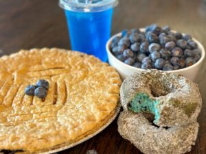 Blueberry pie, donuts, lemonade by bowl of fresh blueberries
