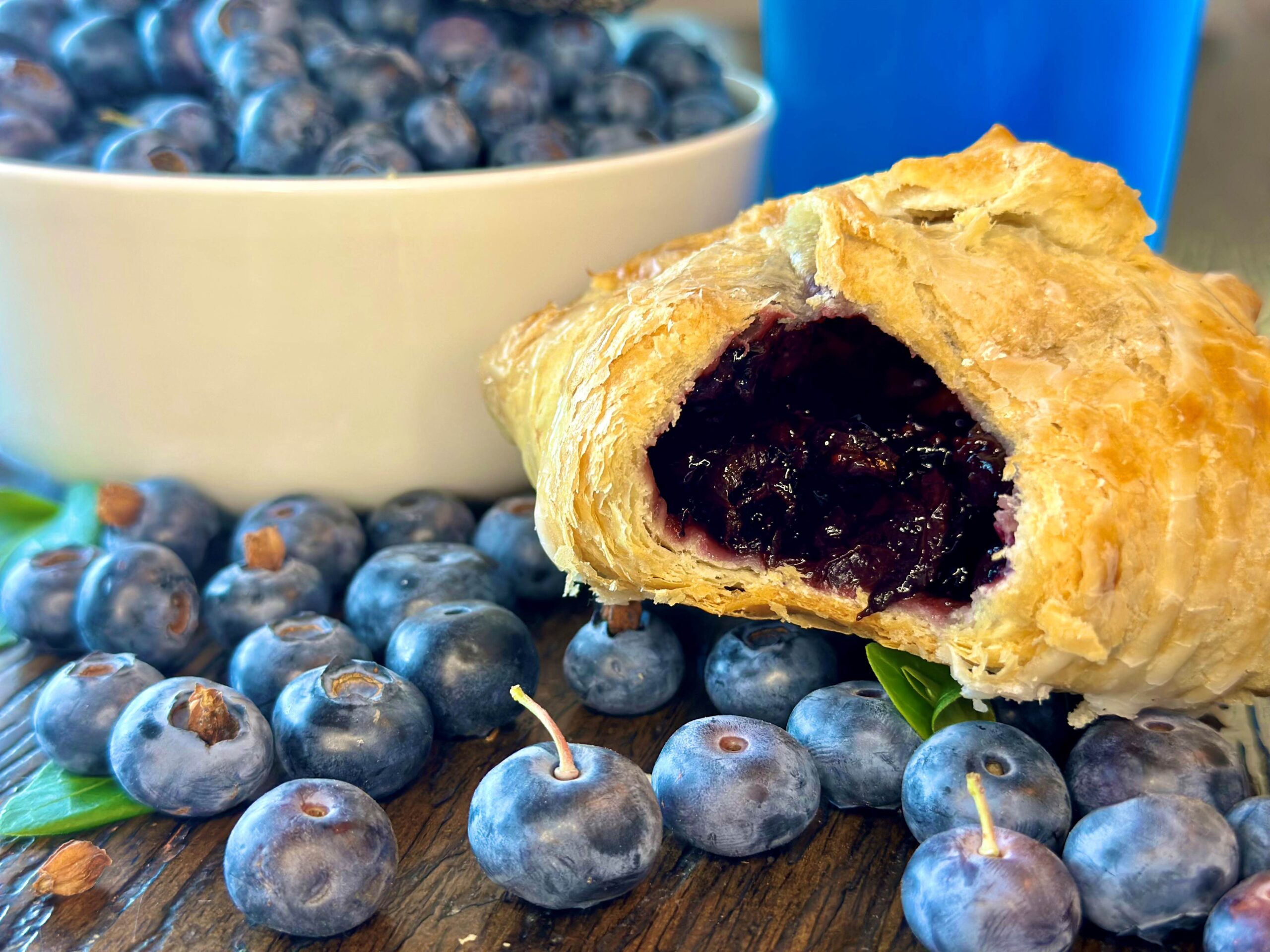 Blueberry turnover surrounded by fresh blueberries