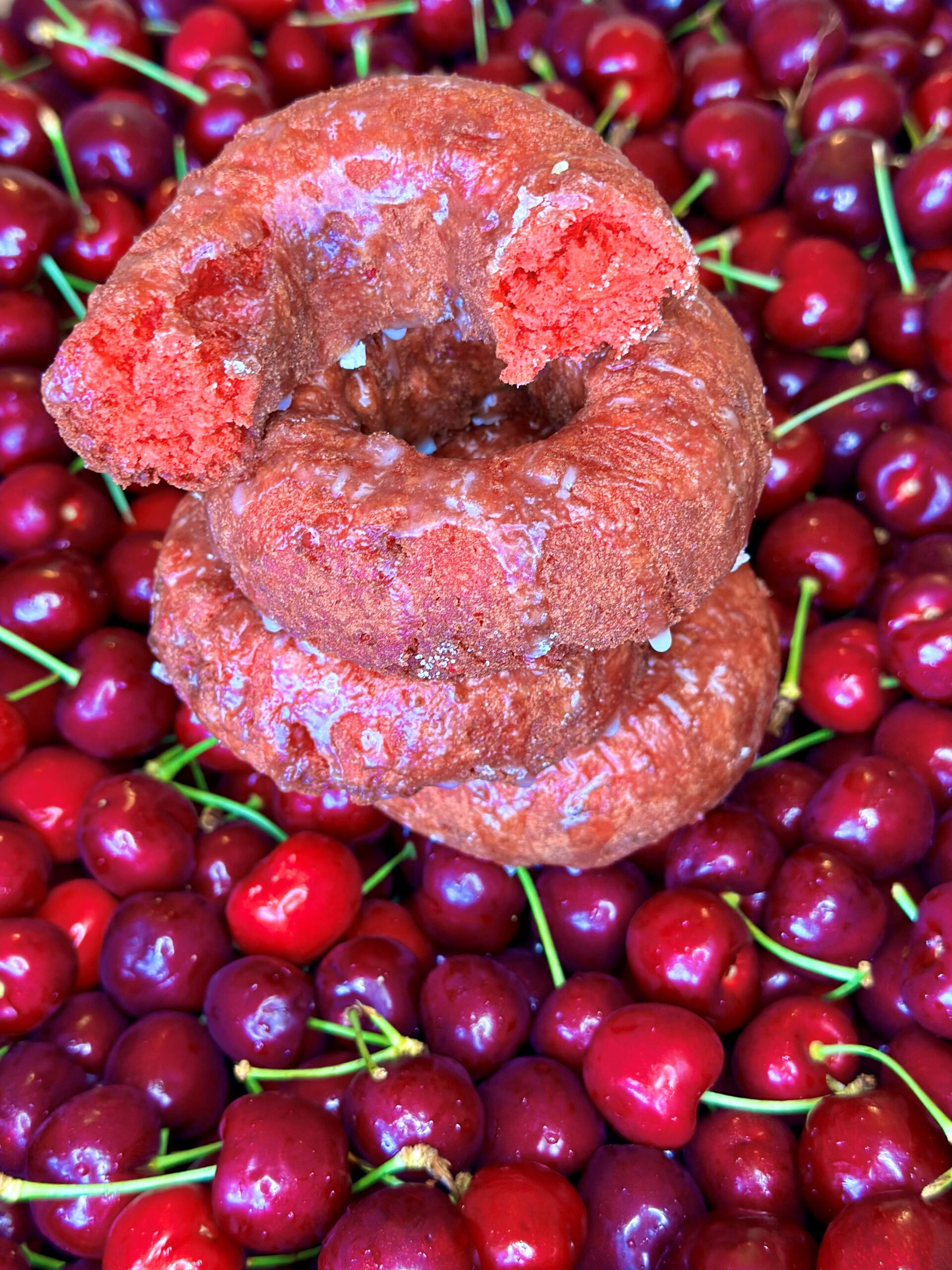 Stack of cherry donuts on top of cherries